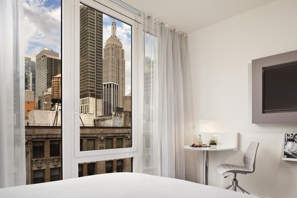 Lit double face à la skyline depuis l'hôtel Innside by Meliá New York