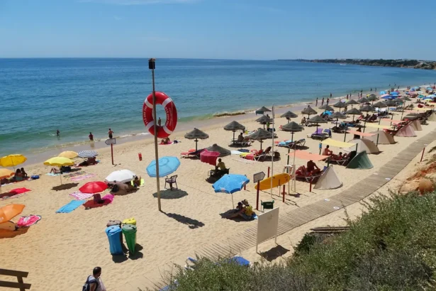 La plage de Falésia près d'Albufeira, ses rangées de parasols sur le sable et les falaises ocre qui la dominent