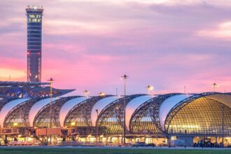 Terminal de l'aéroport de Suvarnabhumi à Bangkok sous un ciel de crépuscule rose