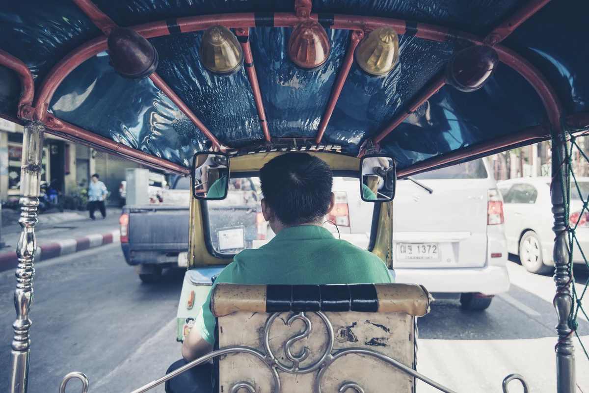 Songkran, le nouvel an thaïlandais : dates, règles et villes où le vivre 2 L'intérieur d'un tuk-tuk dans la circulation de Bangkok, vu depuis la banquette arrière