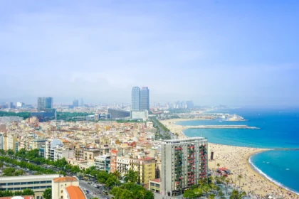 Panorama de Barcelone vu depuis les hauteurs, la ville dense et sa plage filant vers la Méditerranée