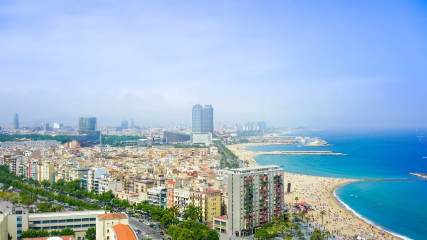 Panorama de Barcelone vu depuis les hauteurs, la ville dense et sa plage filant vers la Méditerranée