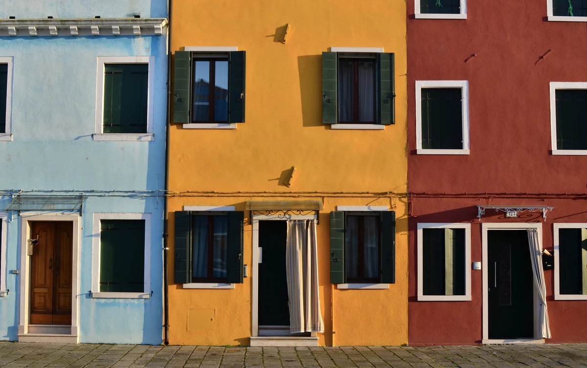Burano et les îles de la lagune de Venise : le guide complet 3 Les façades de Burano peintes en orange et en bleu vif, avec leurs volets