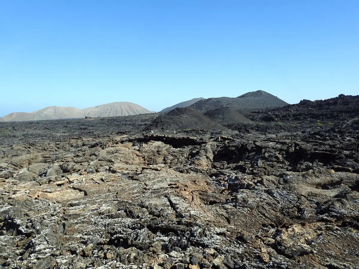 Les coulées de lave noire du parc de Timanfaya à Lanzarote, hérissées de cônes volcaniques