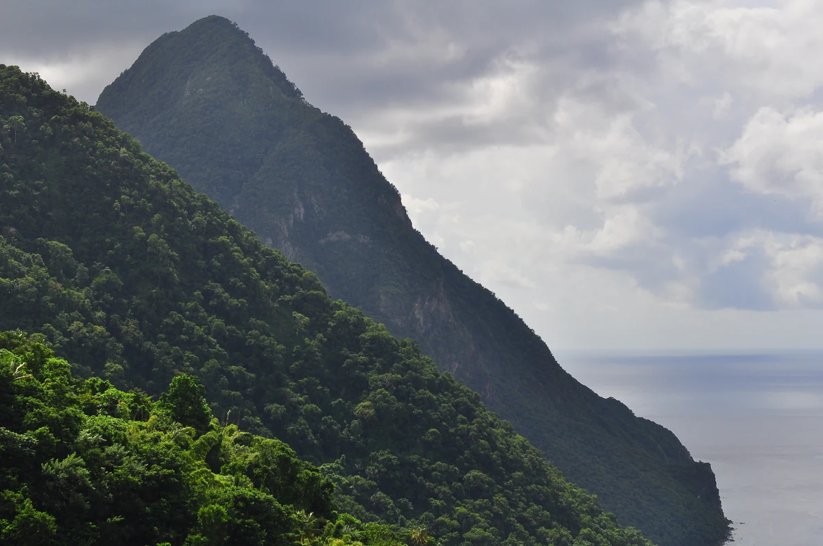 Quand partir aux Caraïbes : le guide complet, mois par mois et île par île 2 Les pitons volcaniques de Sainte-Lucie plongeant dans la mer des Caraïbes, sous les nuages