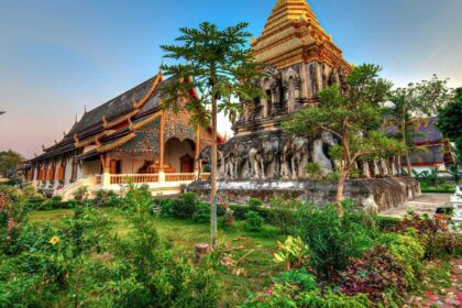 Temple en bois et en brique de la vieille ville de Chiang Mai, entouré d'un jardin fleuri