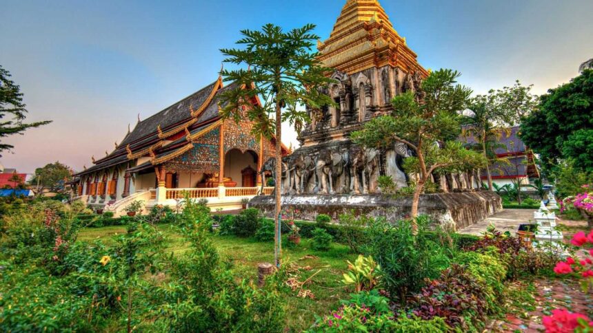 Temple en bois et en brique de la vieille ville de Chiang Mai, entouré d'un jardin fleuri