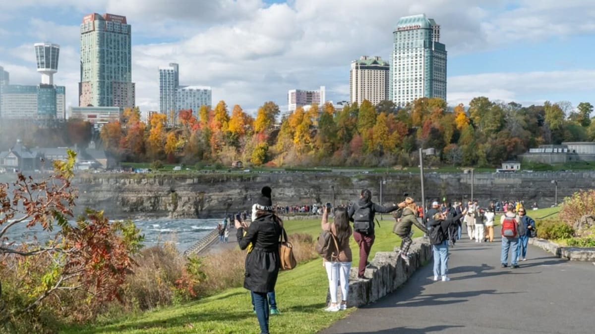 Excursion aux chutes du Niagara depuis New York : 1 jour ou 2 4 Visiteurs sur un sentier côté américain des chutes du Niagara, face à la rive canadienne
