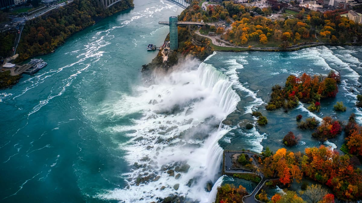 Excursion aux chutes du Niagara depuis New York : 1 jour ou 2 5 Vue aérienne des chutes américaines du Niagara entourées de forêts aux couleurs d'automne