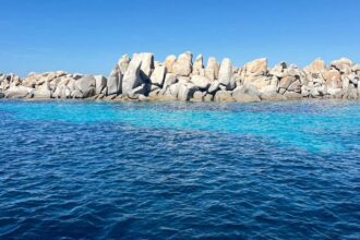 Blocs de granit clair émergeant d'une eau turquoise et transparente, dans le sud de la Corse