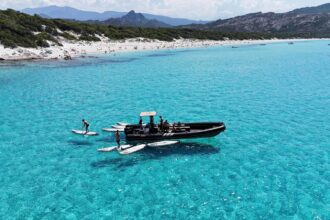 Plage de sable blanc et eau turquoise peu profonde adossée au maquis, sur la côte nord de la Corse
