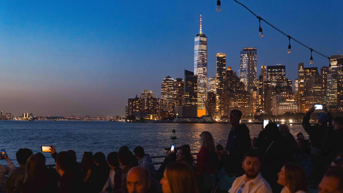 Croisière à Manhattan : quel bateau choisir et à quel prix 2 Passagers sur le pont d'un bateau de croisière au crépuscule, face à Lower Manhattan