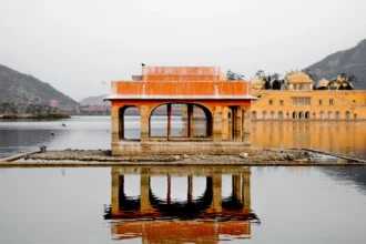 Le palais Jal Mahal posé au milieu de son lac à Jaipur, en Inde, avec les collines en arrière-plan