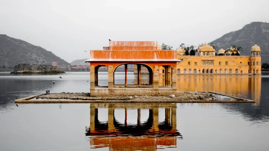 Le palais Jal Mahal posé au milieu de son lac à Jaipur, en Inde, avec les collines en arrière-plan