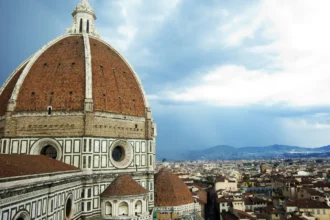 La coupole de brique de Brunelleschi coiffant le Duomo de Florence, avec les toits de la ville et les collines derrière