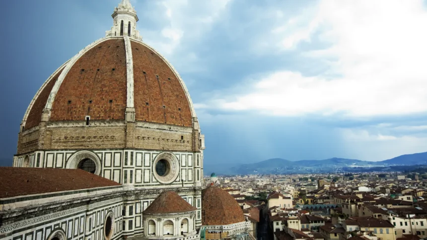 La coupole de brique de Brunelleschi coiffant le Duomo de Florence, avec les toits de la ville et les collines derrière