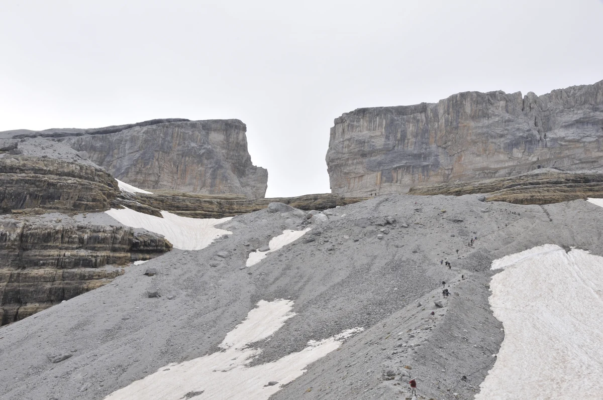 Cirque de Gavarnie : la randonnée jusqu'à la Grande Cascade, itinéraires et conseils 4 La brèche de Roland, l'entaille rectangulaire ouverte dans la crête frontalière, avec ses névés au premier plan