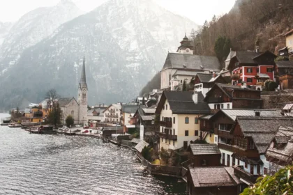 Le village de Hallstatt vu depuis le lac, ses maisons serrées entre l'eau et la montagne autour du clocher de l'église