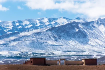 Sommets enneigés du Haut Atlas marocain dominant un village de terre ocre