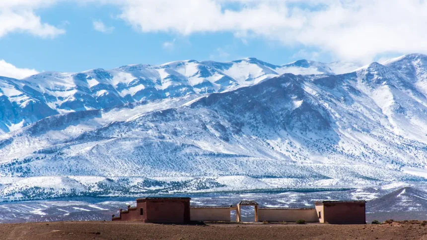 Sommets enneigés du Haut Atlas marocain dominant un village de terre ocre