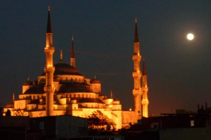 La Mosquée Bleue illuminée à la nuit tombée, ses minarets et ses coupoles se détachant au-dessus des toits d'Istanbul