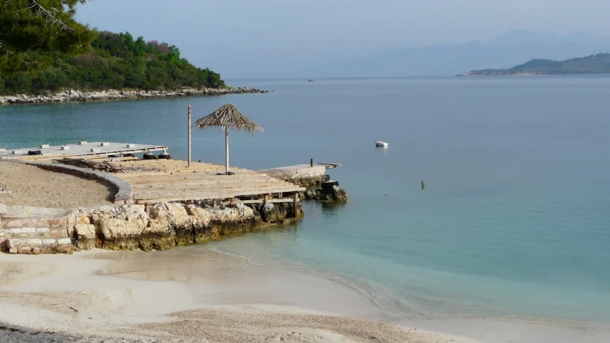 Une plage de Ksamil en Albanie, son ponton de bois avançant sur une eau turquoise et sa bande de sable clair