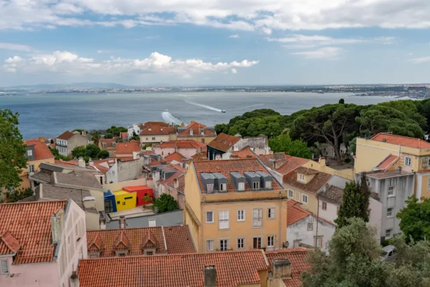 La vue depuis un miradouro de Lisbonne sur les toits de tuiles et le Tage en arrière-plan