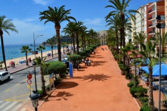 La promenade du front de mer de Lloret de Mar, bordée de palmiers, avec la plage et la Méditerranée en arrière-plan