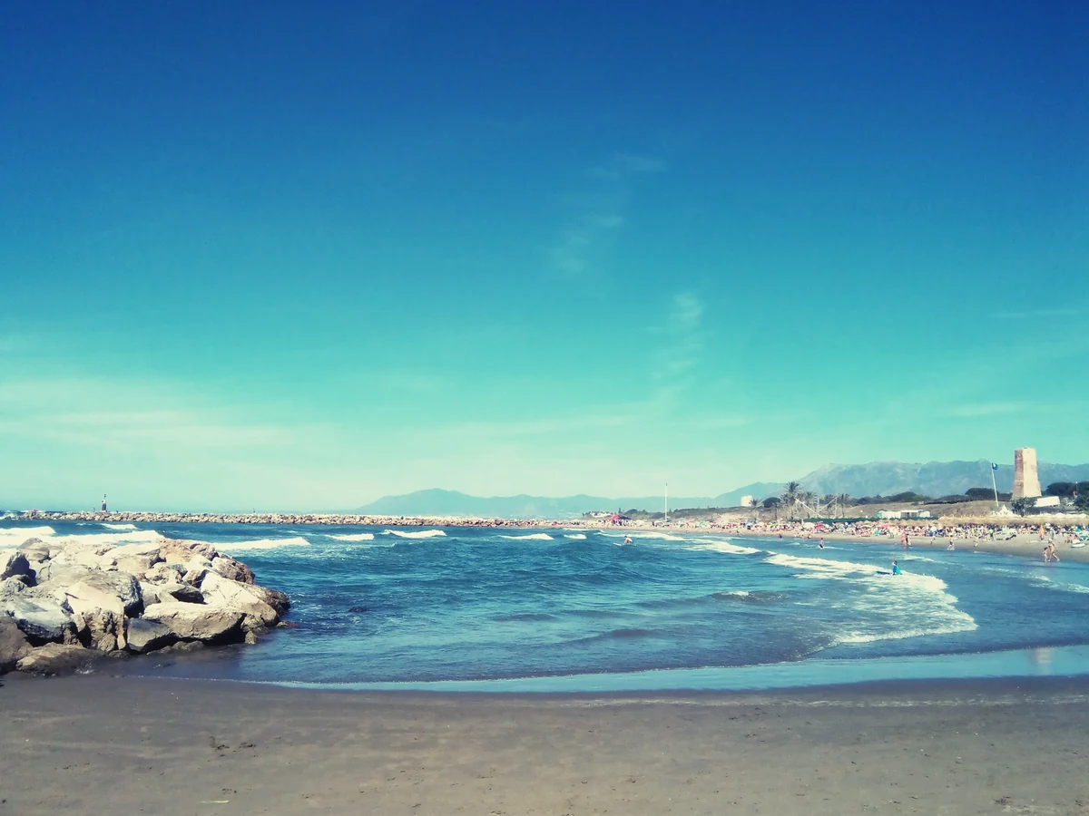 Beach clubs de Marbella : les 10 adresses et le piège du transat qu'on croit payant 2 Une plage de Marbella et ses eaux turquoise, avec le littoral qui file vers l'horizon
