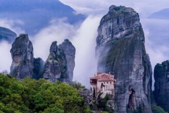 Le monastère de Roussanou émergeant de la brume entre les piliers de grès des Météores