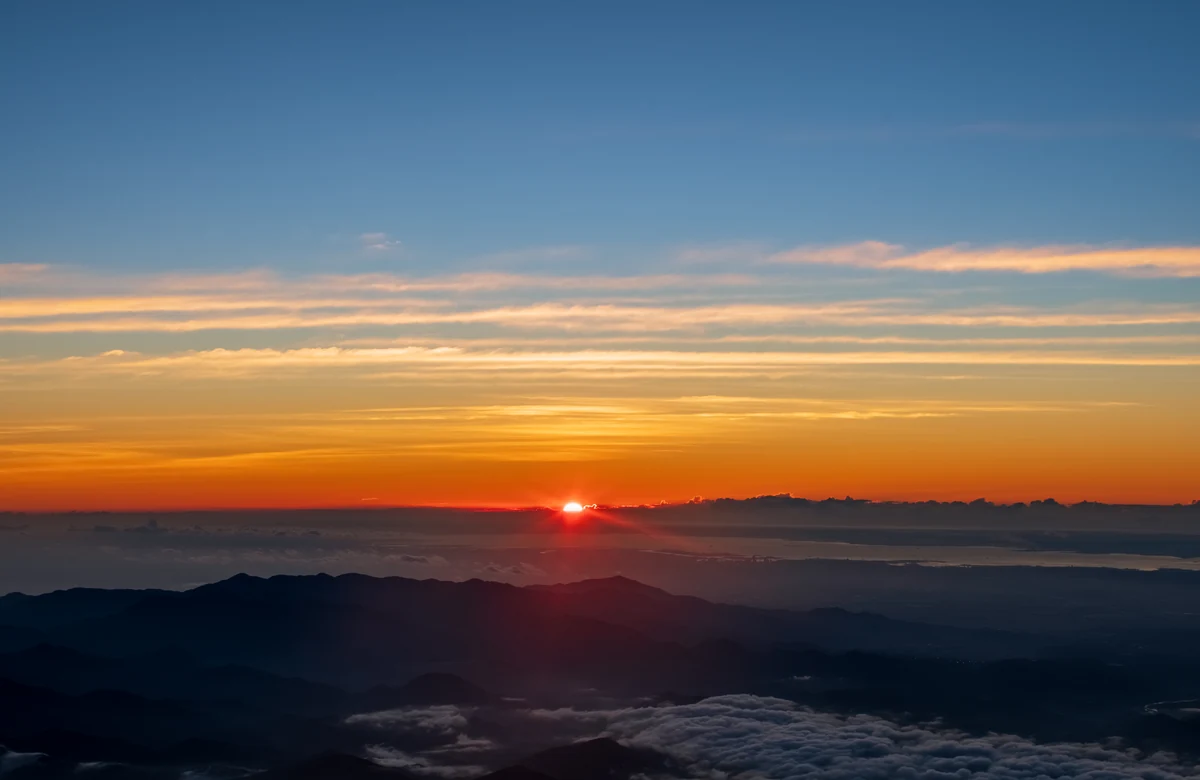 Mont Fuji : le voir et le gravir, deux projets à ne pas confondre 3 Le lever du soleil vu depuis les pentes du mont Fuji, le disque orange émergeant au-dessus d'une mer de nuages