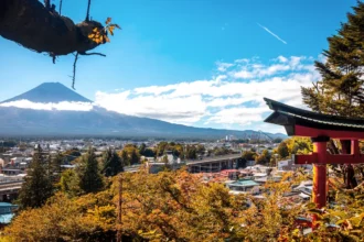 Le mont Fuji enneigé vu au-dessus d'une pagode japonaise et des érables roux, depuis les hauteurs de Fujiyoshida