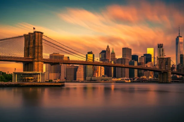 Le pont de Brooklyn et la skyline de Manhattan au coucher du soleil, reflétés dans l'East River