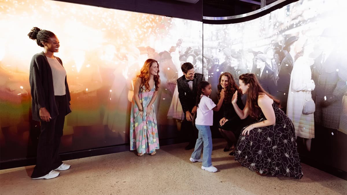 Billets pour le Skywalk One Times Square : prix, horaires et avis du nouvel observatoire 6 Salle immersive Eternal Midnight du parcours Times Travel à One Times Square, visiteurs entourés de projections de fêtards du réveillon