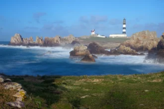 Le phare du Créac'h et ses bandes noires et blanches dressé sur la côte rocheuse d'Ouessant, face à la mer d'Iroise