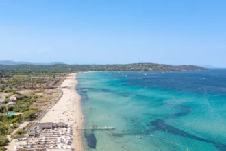 Vue aérienne de la plage de Pampelonne à Ramatuelle, avec la longue bande de sable bordée par les beach clubs et les eaux turquoise de la baie de Saint-Tropez