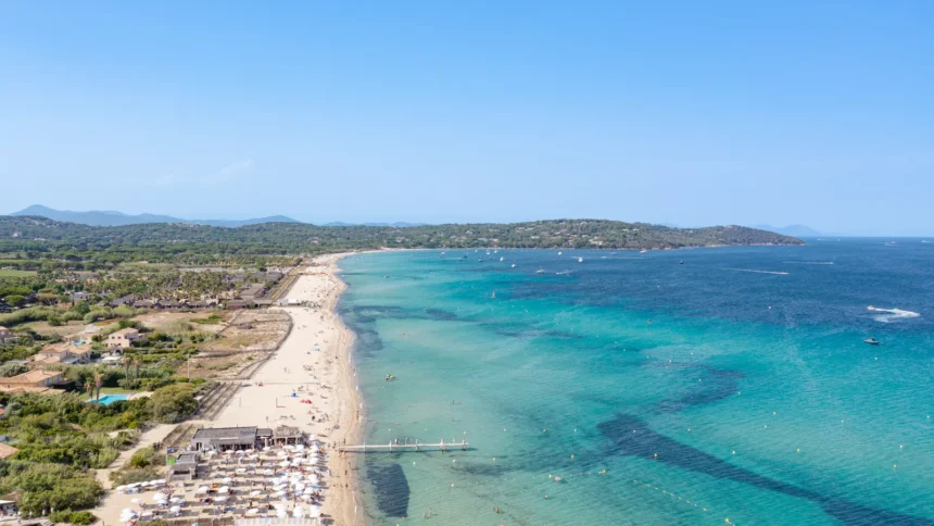 Vue aérienne de la plage de Pampelonne à Ramatuelle, avec la longue bande de sable bordée par les beach clubs et les eaux turquoise de la baie de Saint-Tropez