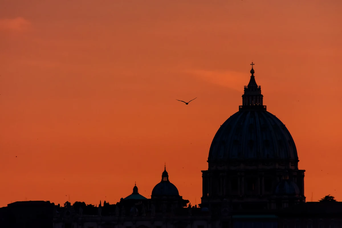Rooftops de Rome : 12 terrasses classées par le monument qu'elles regardent 3 La coupole de Saint-Pierre en silhouette dans un ciel orangé au crépuscule