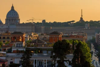 Panorama de Rome au coucher du soleil depuis une terrasse en hauteur, les coupoles se détachant dans la lumière dorée