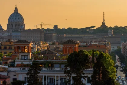 Panorama de Rome au coucher du soleil depuis une terrasse en hauteur, les coupoles se détachant dans la lumière dorée
