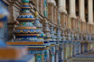 Les arcades de la Plaza de España à Séville, leurs colonnes de brique et leurs azulejos peints en bleu et blanc