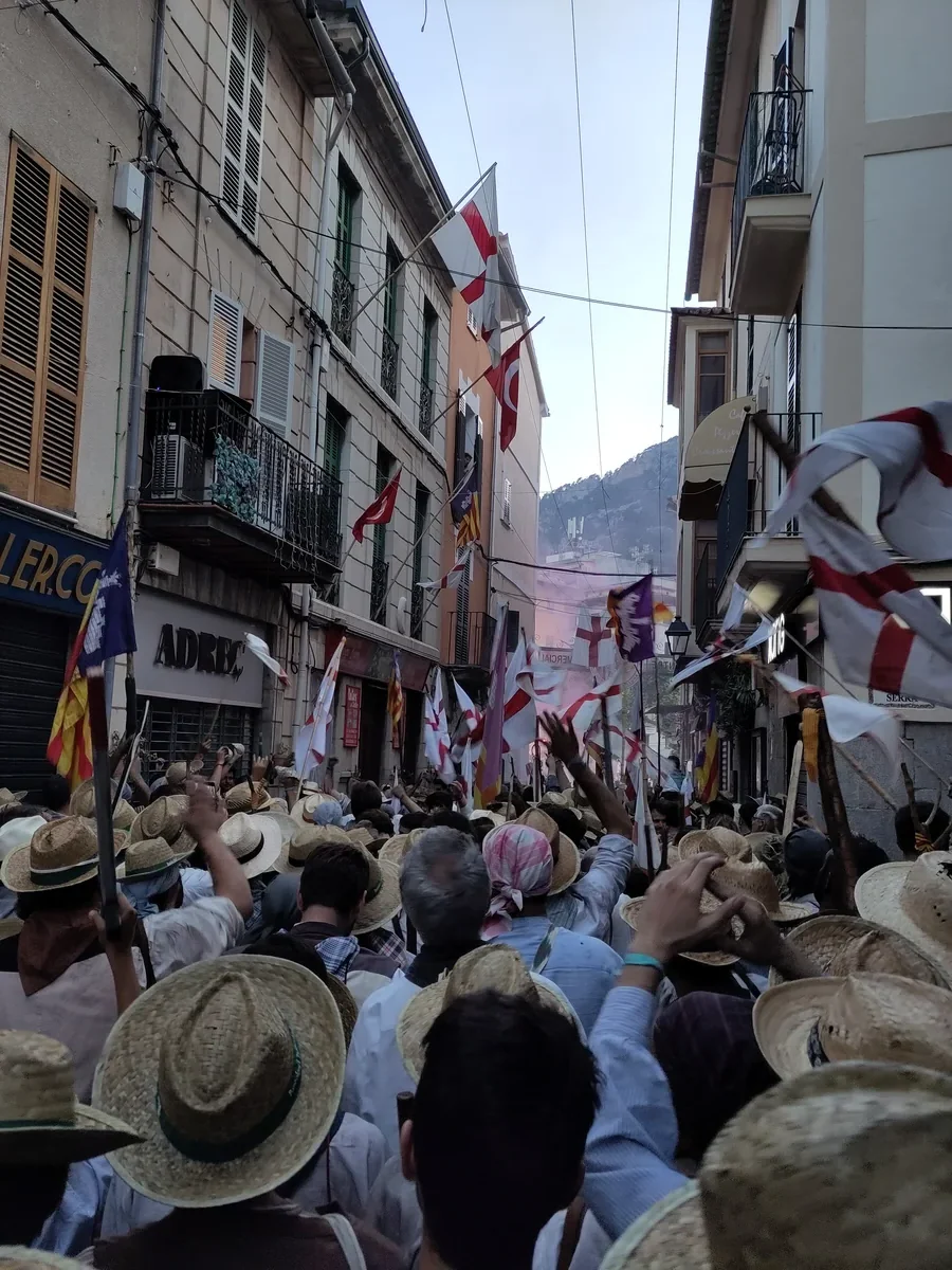 Des étals installés dans une rue de Sóller, avec leurs chapeaux de paille suspendus devant les façades du village