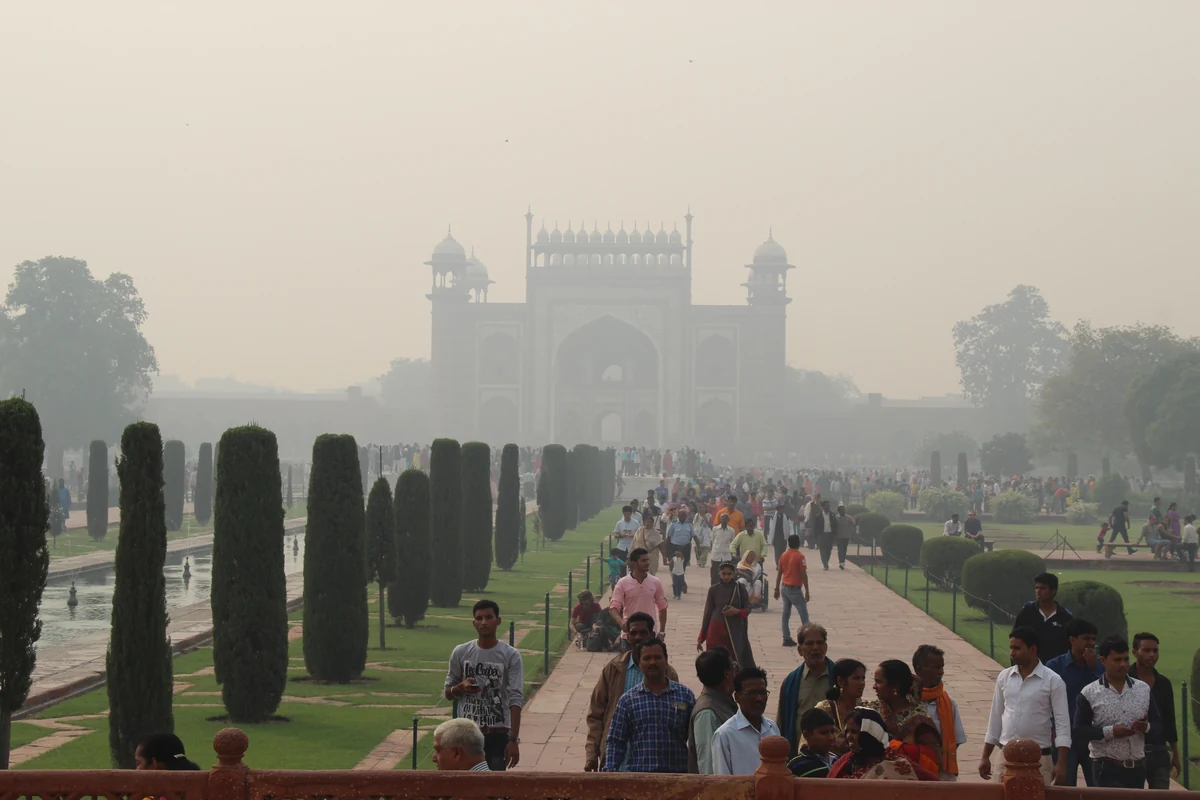 Visiter le Taj Mahal : billets, visite de nuit et pièges à éviter 3 L'allée bordée de cyprès menant au Taj Mahal, avec les visiteurs et le bassin