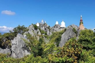 Chapelles blanches perchées sur des pitons rocheux au Wat Chalermprakiat, près de Lampang