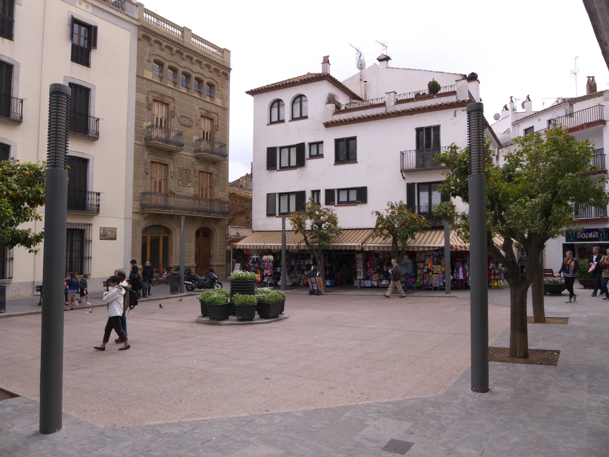 Tossa de Mar : la seule ville fortifiée médiévale de la Costa Brava 3 La place centrale de Tossa de Mar et ses façades claires, sous les arbres