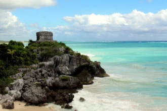 Les ruines mayas de Tulum perchées sur leur falaise, au-dessus d'une plage de sable blanc et d'une mer turquoise