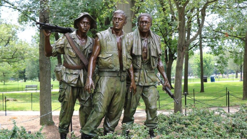 La statue des Trois Soldats du mémorial des vétérans du Vietnam à Washington, trois figures de bronze en tenue de combat au milieu des arbres
